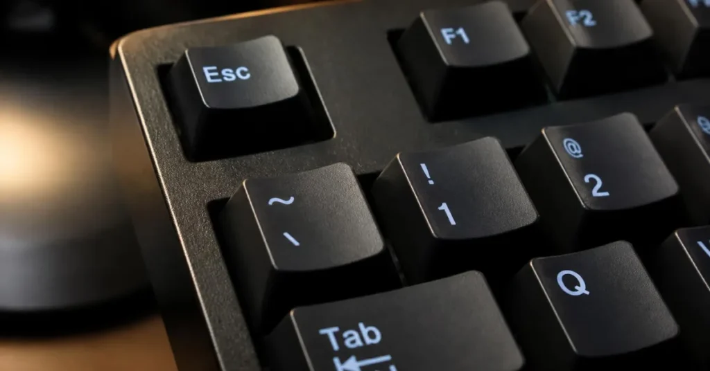 Close up of the tilde and backtick key located above the tab key on a keyboard