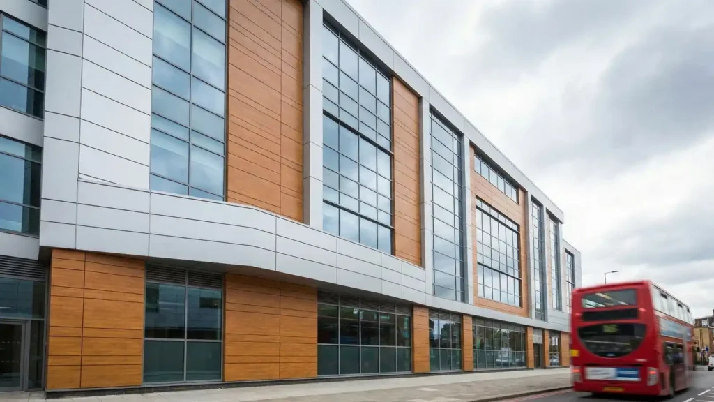 Low-angle view of a contemporary commercial building with Alucobond composite panels contrasting with large glass windows.
