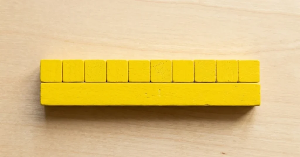 Ten individual yellow blocks aligned side by side against a single solid ten-block rod.
